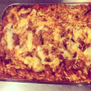 Baked Tomato and Mozzarella Orzo being serviced to pre-schoolers in a dish