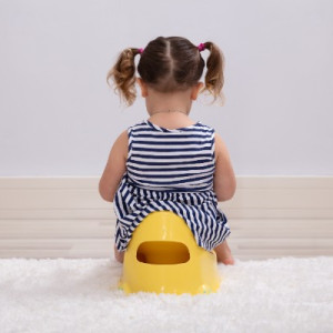 girl sitting on a yellow potty