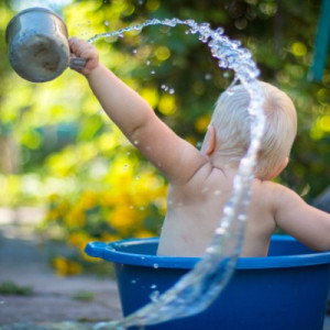 a baby playing with water to Keep Cool during summer