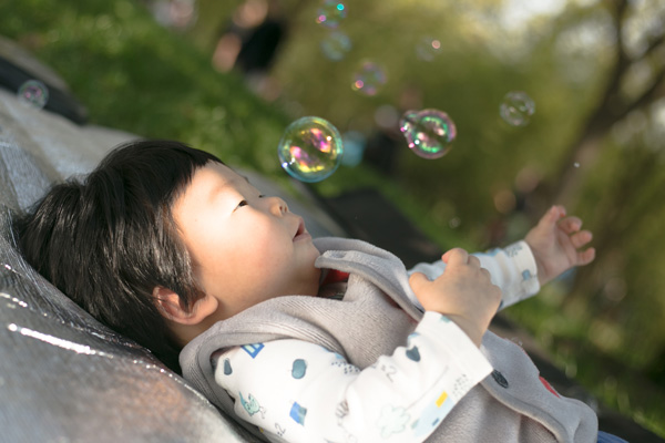 A young child playing with bubbles as part of sensory play