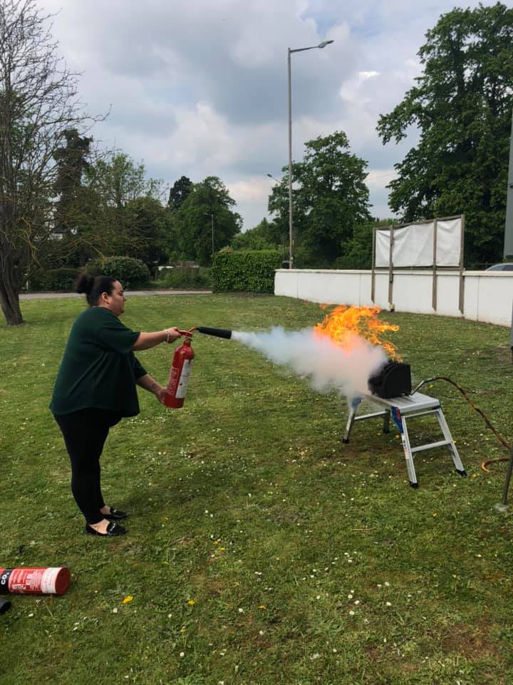 A manager using a fire extinguisher during fire training