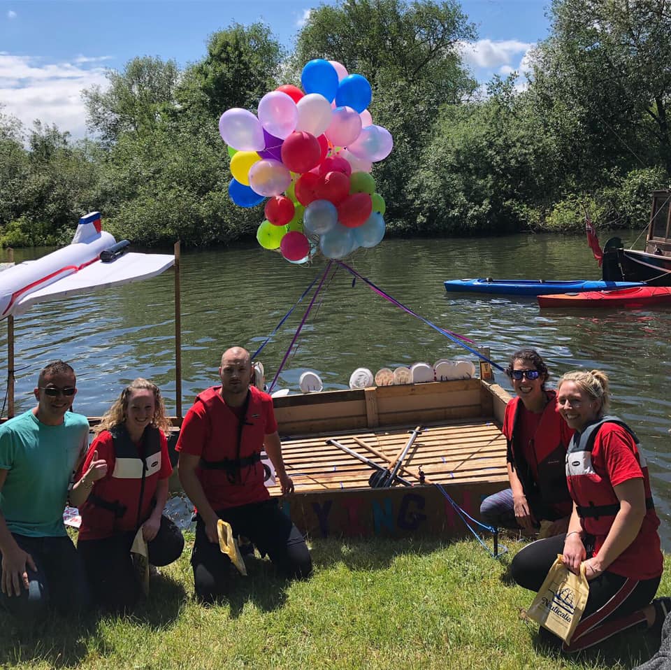 Members of staff at Sheperton Village fair taking part in a raft race